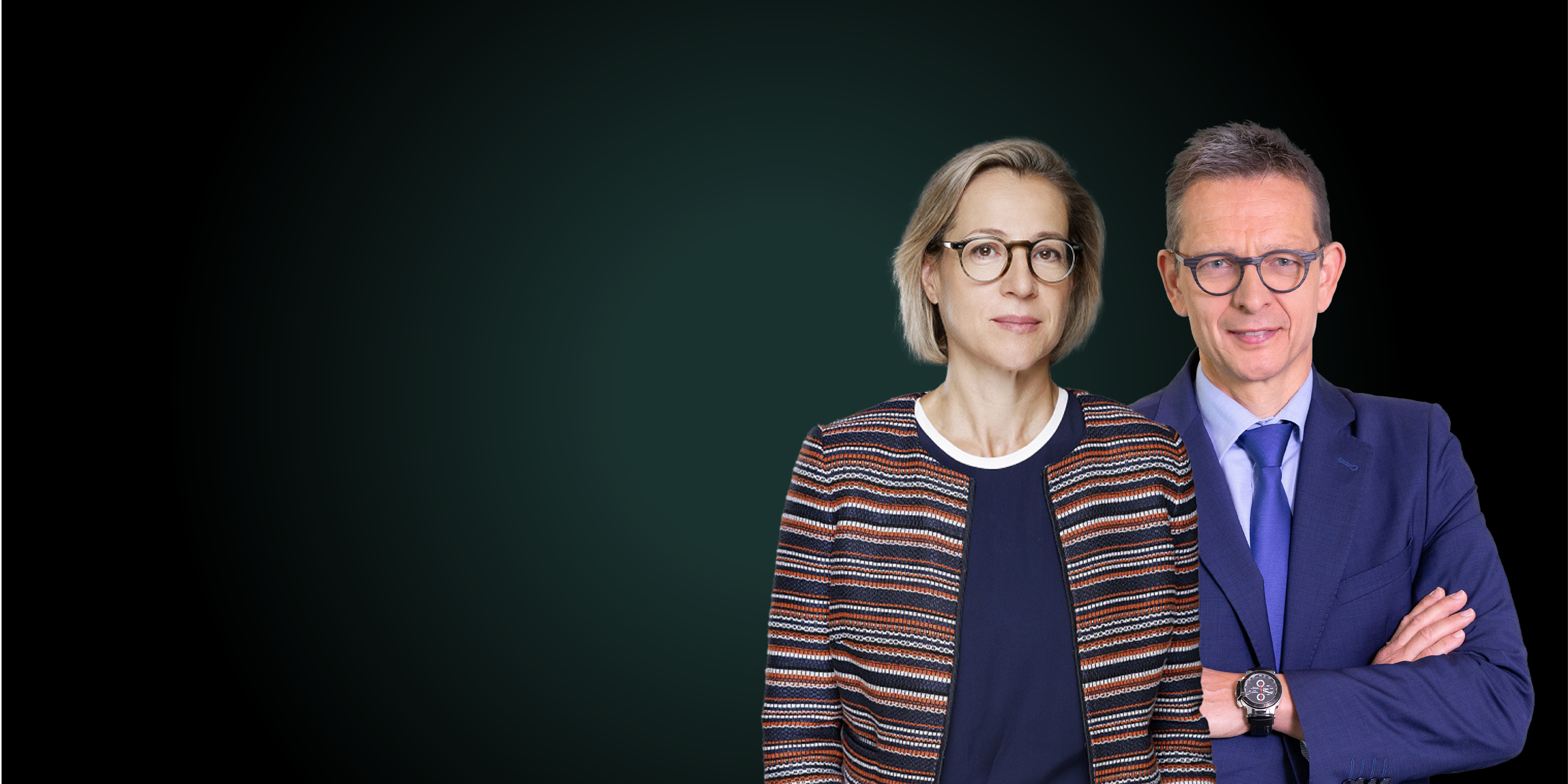 A smiling woman wearing glasses with a smiling man wearing a suit