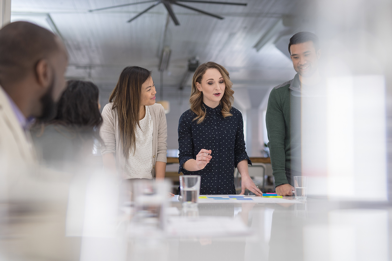 Une réunion dans un espace de travail entre 3 femmes et 2 hommes 