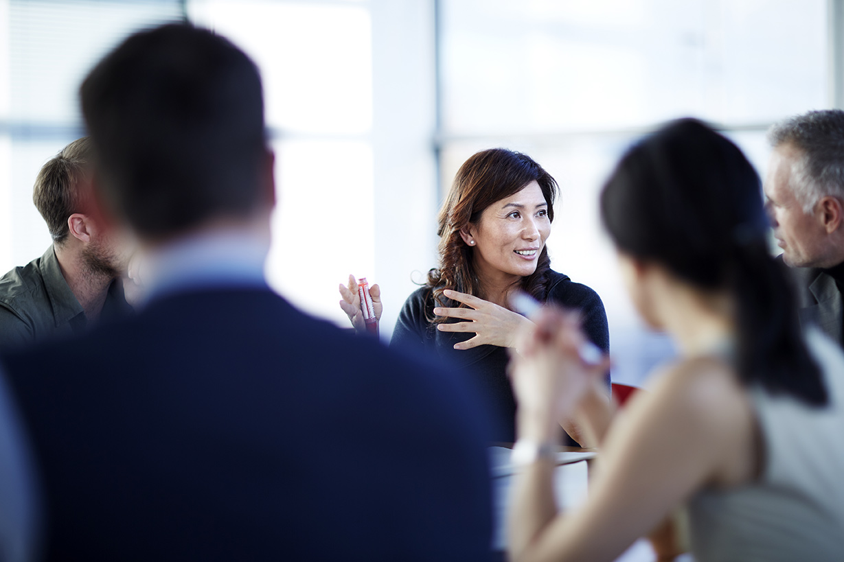 Woman smiling in a meeting with team